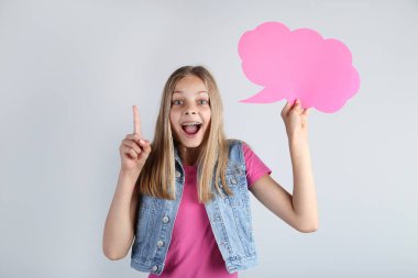 Pembe konuşma balonu gri arka plan üzerinde tutan genç kız