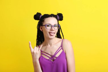 Genç kadın gözlük ve sarı zemin üzerine dreadlocks ile