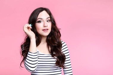 kadın pembe bir arka plan üzerinde maskara ile