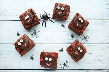 Fresh halloween cookies with spiders on wooden table clipart