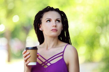 Genç kadın kahve park holding dreadlocks ile