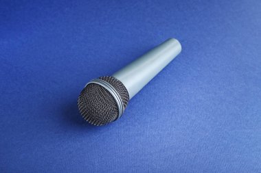 Mavi arka plan üzerinde siyah mikrofon
