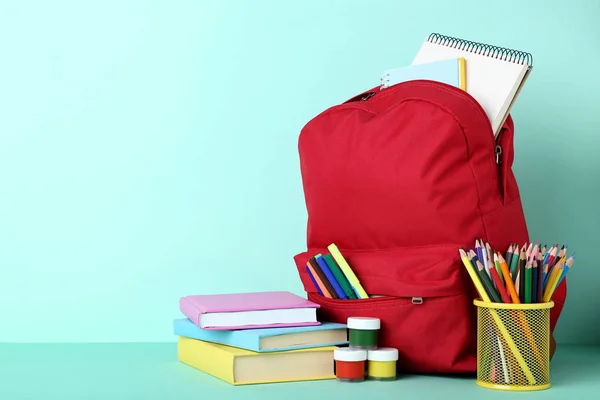 Mochila Roja Con Útiles Escolares Sobre Fondo Menta —  Fotos de Stock