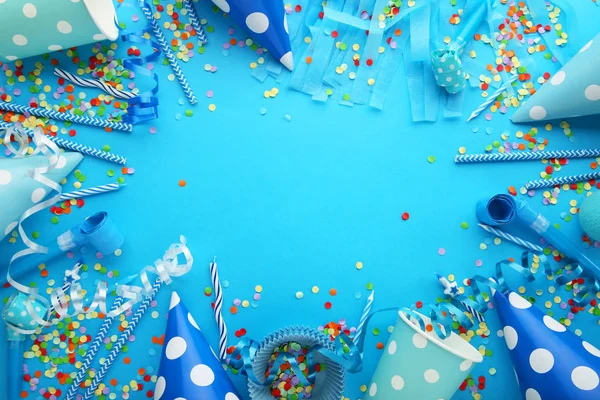 Doğum günü partisi kapaklar, üfleyiciler ve kağıt payet mavi zemin üzerine