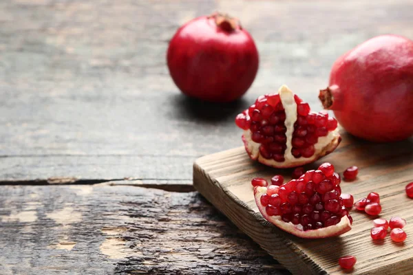 Ripe Juicy Pomegranates Cutting Board Grey Wooden Table — Stock Photo, Image