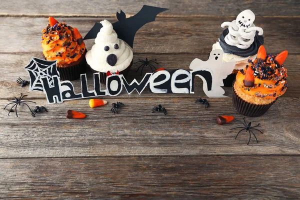 Gri ahşap masa üzerinde şeker ile Halloween cupcakes