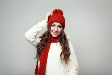 Kazak, atkı ve şapka gri arka plan üzerinde güzel genç kız