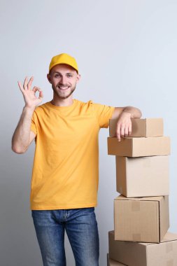 Teslimatçı ile gri arka plan üzerine karton kutular