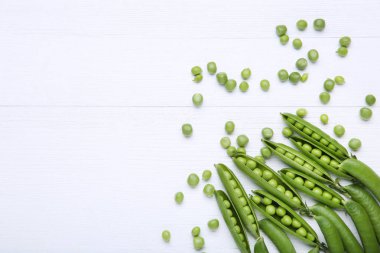 Beyaz ahşap masa üzerinde taze yeşil bezelye
