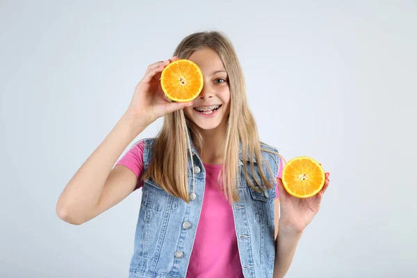 Gadis Tersenyum Muda Dengan Buah Oranye Latar Belakang Abu Abu — Stok Foto