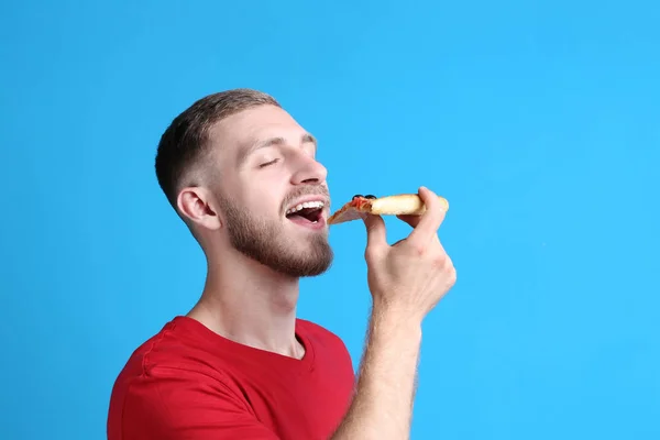 Jovem Comendo Pizza Fundo Azul — Fotografia de Stock