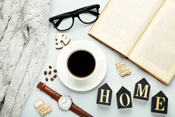 Cup of coffee with book, glasses, watch and grey sweater