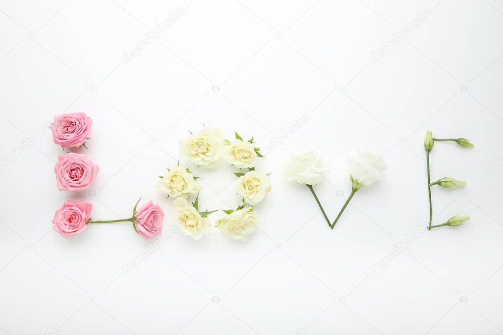 Inscription Love by flowers on white background