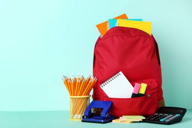 Nane arka plan üzerinde kırmızı sırt çantası ile okul malzemeleri