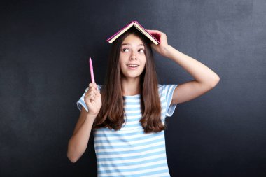 Kitap üzerinde tahta arka plan ile genç kız