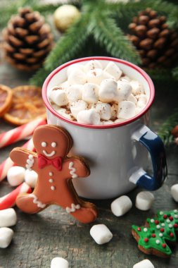 Kapuçino hatmi gingerbread çerezleri üzerinde ahşap masa ile kupa ile