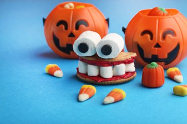 Cadılar Bayramı çerezleri ağız ile mavi arka plan üzerinde marshmallows