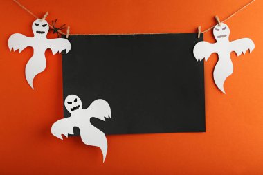 Cadılar Bayramı hayaletler ve siyah çerçeve üzerinde turuncu arka plan asılı
