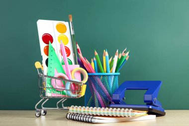 Defter üzerinde kara tahta arka plan ile okul malzemeleri