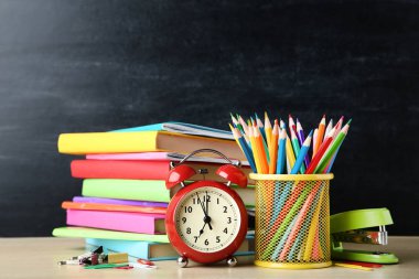 Blackboard zemin üzerine kalem ve çalar saat ile okul kitapları