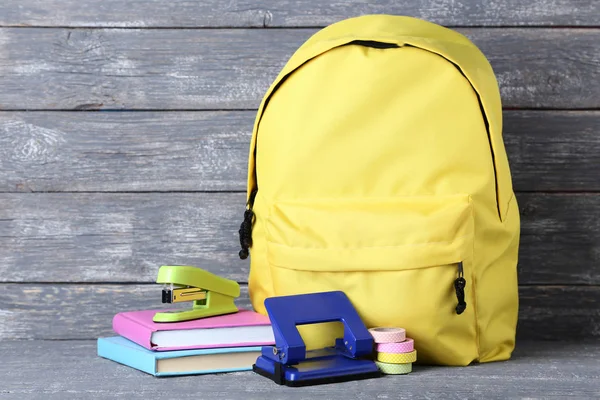 Mochila Amarilla Con Útiles Escolares Sobre Fondo Madera —  Fotos de Stock