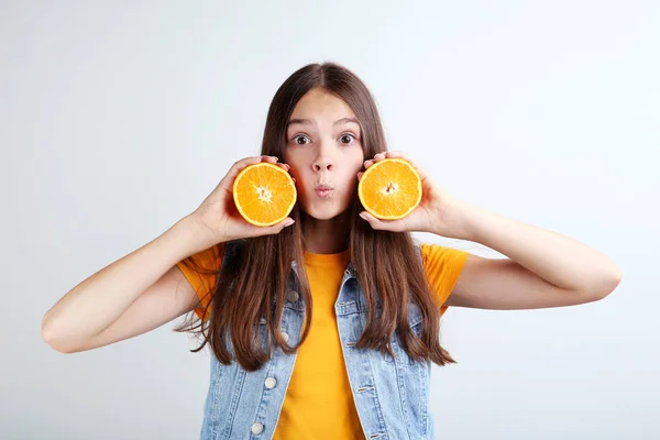 Gadis Muda Dengan Buah Oranye Dengan Latar Belakang Abu Abu — Stok Foto