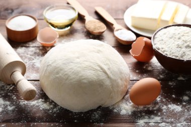 Yumurta ve un üzerinde ahşap masa ile çiğ hamur