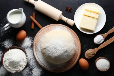 Plaka ve ahşap masa üzerinde un tereyağı ile çiğ hamur