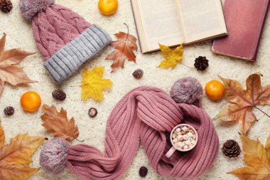 Kahve pembe atkı ve şapka, mandalina ve kuru yapraklar ile fincan