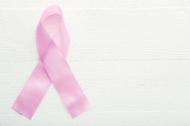 Beyaz ahşap masa üzerinde pembe kurdele