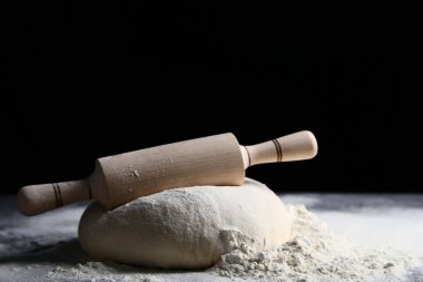 Ahşap masa üzerinde oklava ile çiğ hamur