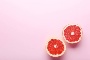 Olgun greyfurt dilim pembe bir arka plan üzerinde
