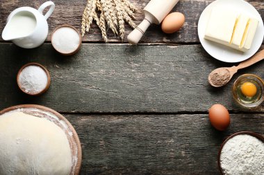 Tereyağı, yumurta ve süt kabı ahşap masa üzerinde çiğ hamur