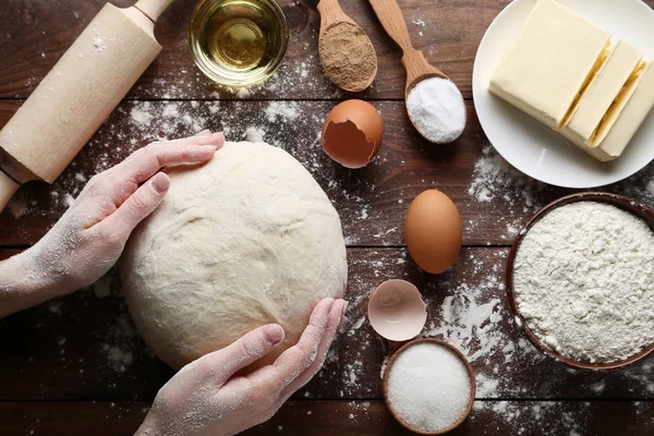 Kvinna Händer Innehav Deg Med Ägg Och Mjöl Träbord — Stockfoto