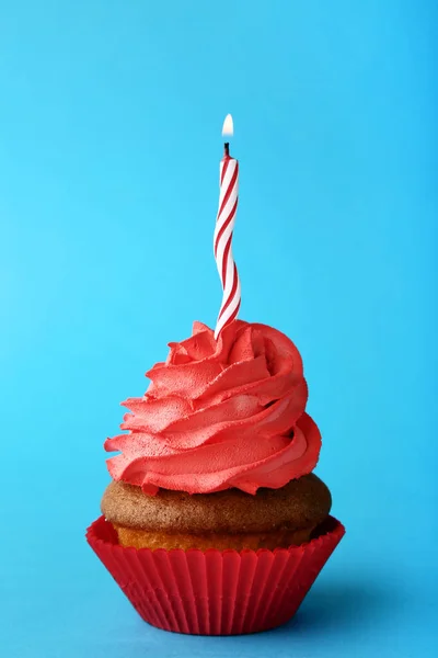 Sabroso Cupcake Con Vela Sobre Fondo Azul —  Fotos de Stock
