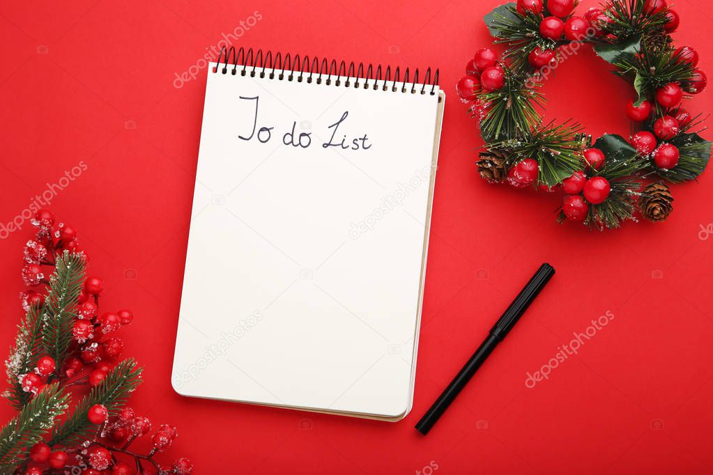 To do list in notepad with christmas wreath on red background