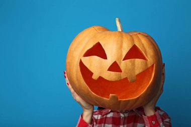 Cadılar Bayramı Balkabağı mavi arka plan üzerinde tutan erkek eller