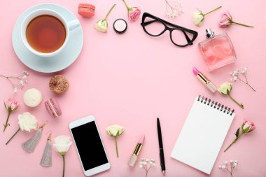 Fincan çay ve makyaj kozmetik pembe bir arka plan üzerinde çiçeklerle