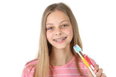 Diş ile genç gülümseyen kız beyaz arka plan üzerinde izole diş fırçası diş teli