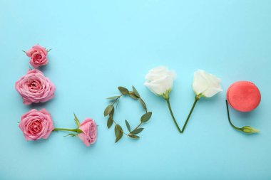 Çiçekler ve acıbadem kurabiyesi mavi arka plan üzerinde yazıt aşk