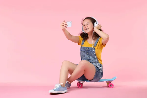 Ung Flicka Att Göra Selfie Och Sitter Skateboard Rosa Bakgrund — Stockfoto