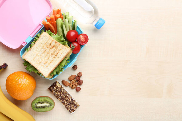 School lunch box with fruits and vegetables on wooden table