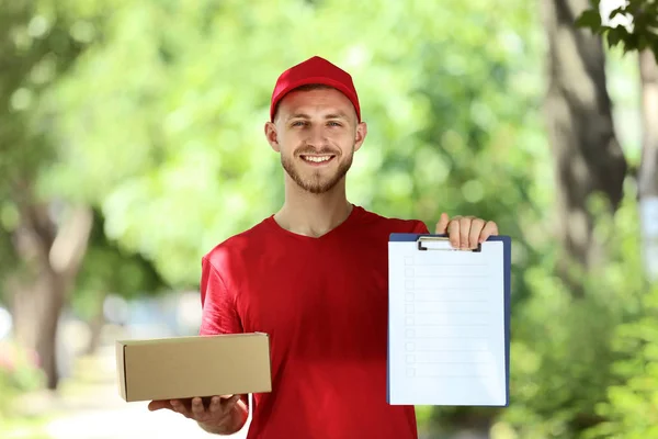 Delivery Man Holding Cardboard Box Clipboard Blurred Natural Background — Stock Photo, Image