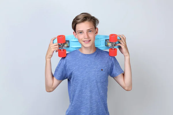 Lachende Tiener Jongen Holding Skateboard Grijze Achtergrond — Stockfoto