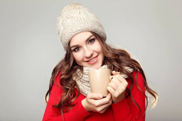 美丽的年轻女孩在温暖的帽子和围巾捧着一杯茶 — 图库照片