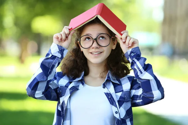 Jovem Menina Óculos Segurando Livro Cabeça Parque — Fotografia de Stock