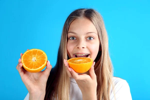 Young Smiling Girl Dental Braces Biting Orange Fruit Blue Background — Stock Photo, Image