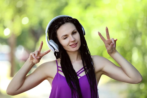 Linda Mujer Joven Escuchando Música Los Auriculares Mostrando Símbolos Paz —  Fotos de Stock