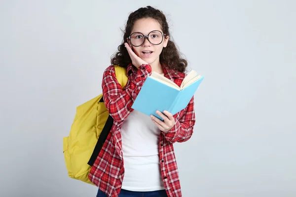 Schönes Junges Mädchen Mit Buch Und Rucksack Auf Grauem Hintergrund — Stockfoto