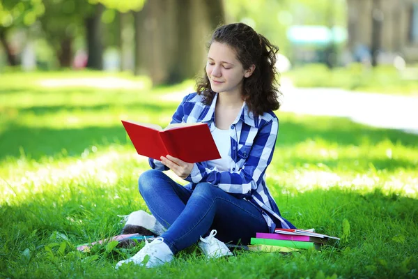 Молода Дівчина Читає Книгу Сидячи Траві Парку — стокове фото